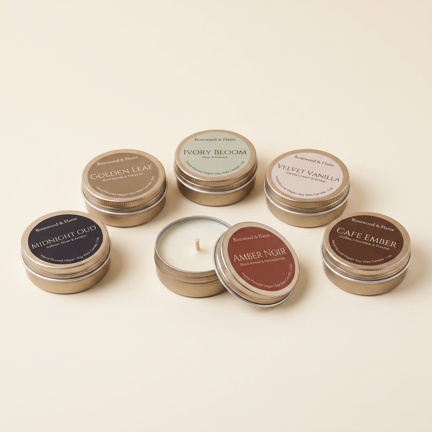 Six small round metal candle tins arranged on a warm cream background. One tin is open, showing white wax, while the others are closed with round labels in different colors including dark blue, gold, pale blue, brown, and taupe.